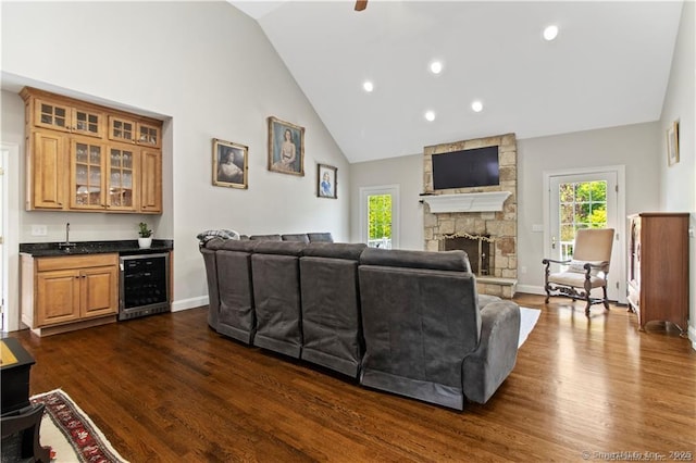 living room featuring bar area, dark hardwood / wood-style flooring, a fireplace, and beverage cooler