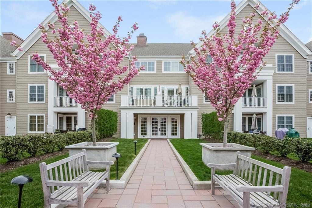 back of property featuring french doors, a balcony, a patio, and a lawn