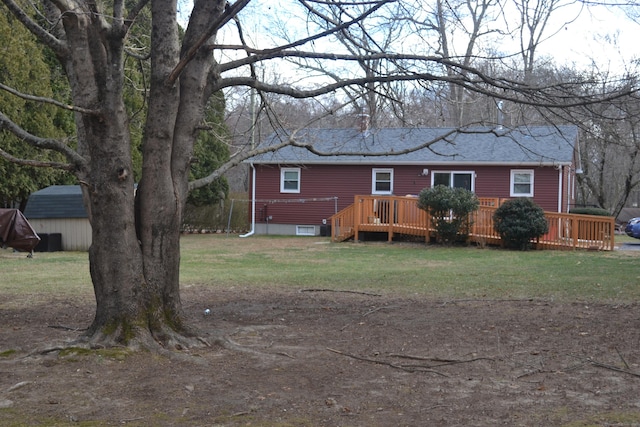 back of house with a deck and a lawn