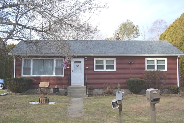 view of front of house with a front lawn and central AC unit