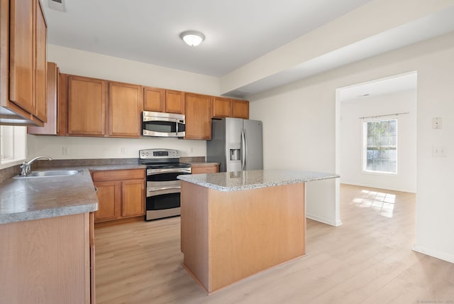 kitchen featuring sink, a kitchen island, light hardwood / wood-style floors, and appliances with stainless steel finishes