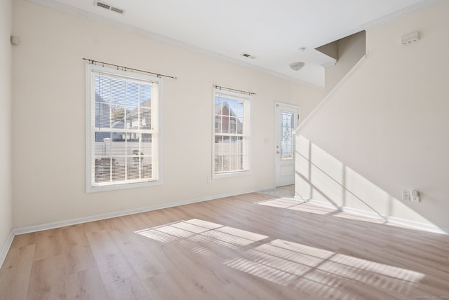 spare room with light hardwood / wood-style floors and crown molding