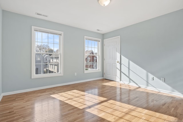 spare room with light hardwood / wood-style flooring and a healthy amount of sunlight