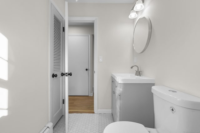 bathroom with toilet, vanity, tile patterned floors, and a baseboard heating unit