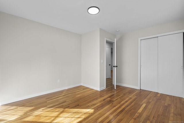 unfurnished bedroom featuring a closet and hardwood / wood-style floors