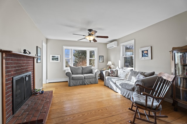 living room featuring hardwood / wood-style floors, a baseboard heating unit, ceiling fan, a brick fireplace, and a wall mounted air conditioner