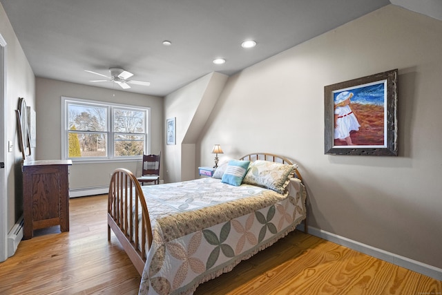 bedroom featuring ceiling fan, light hardwood / wood-style floors, and a baseboard radiator