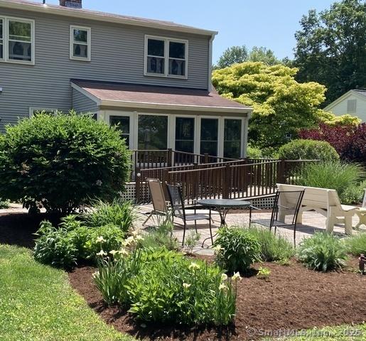 rear view of property featuring a sunroom and a patio