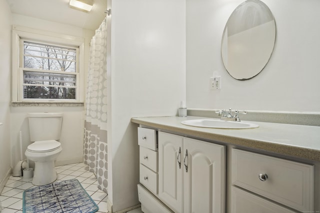 bathroom with toilet, vanity, and tile patterned flooring