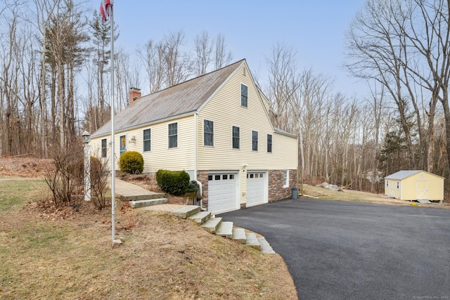 view of side of home with a storage unit and a garage