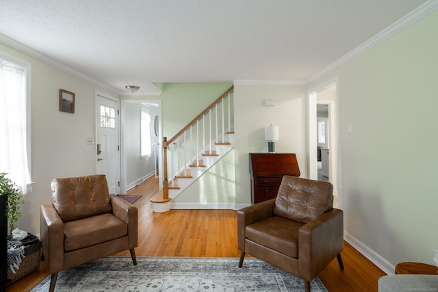 living area with hardwood / wood-style floors and crown molding