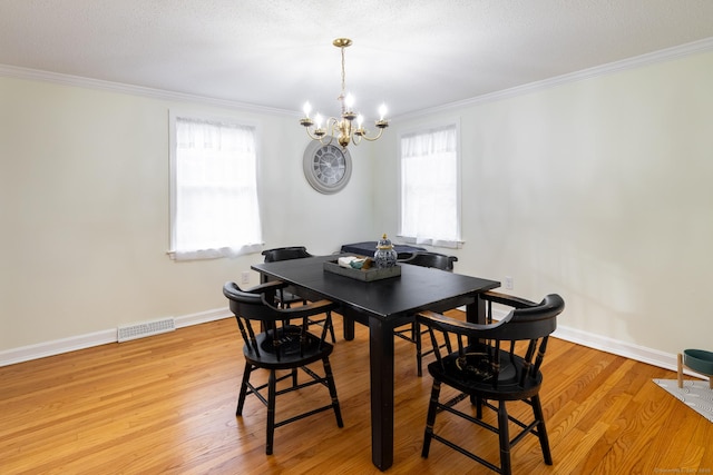 dining space featuring an inviting chandelier, light hardwood / wood-style floors, crown molding, and plenty of natural light