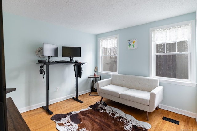 interior space with a textured ceiling and hardwood / wood-style flooring