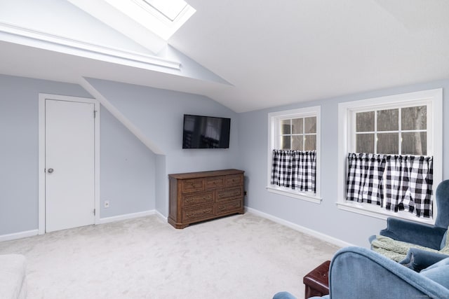 living area featuring light colored carpet and lofted ceiling with skylight