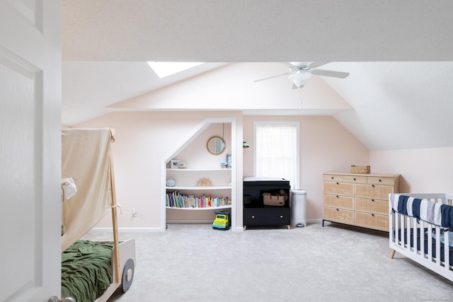 carpeted bedroom with ceiling fan and lofted ceiling with skylight