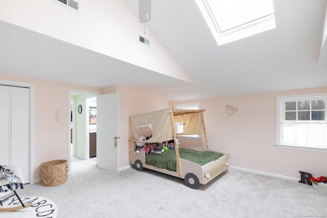 bedroom with a closet, lofted ceiling with skylight, and carpet