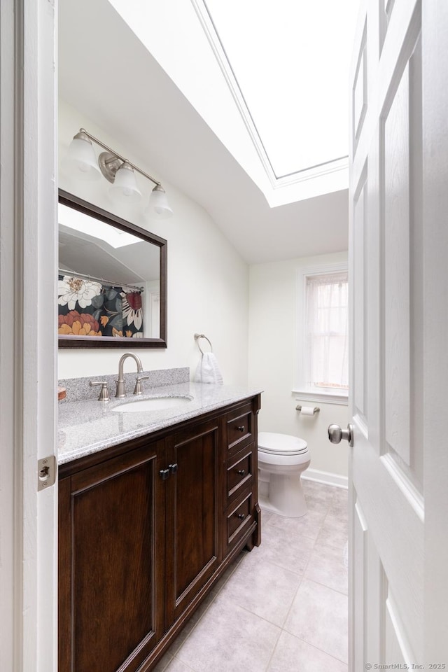 bathroom featuring lofted ceiling, tile patterned flooring, vanity, and toilet