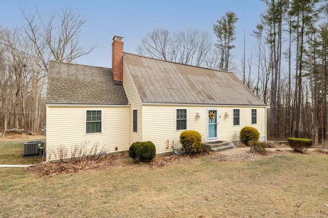 cape cod house with central AC and a front yard