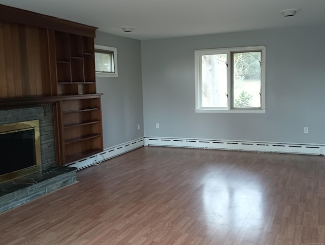 unfurnished living room with hardwood / wood-style flooring, a fireplace, and a baseboard radiator