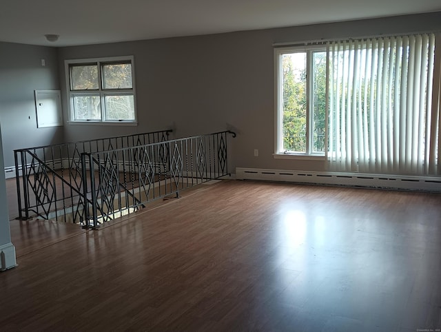 unfurnished room with a baseboard radiator and hardwood / wood-style flooring