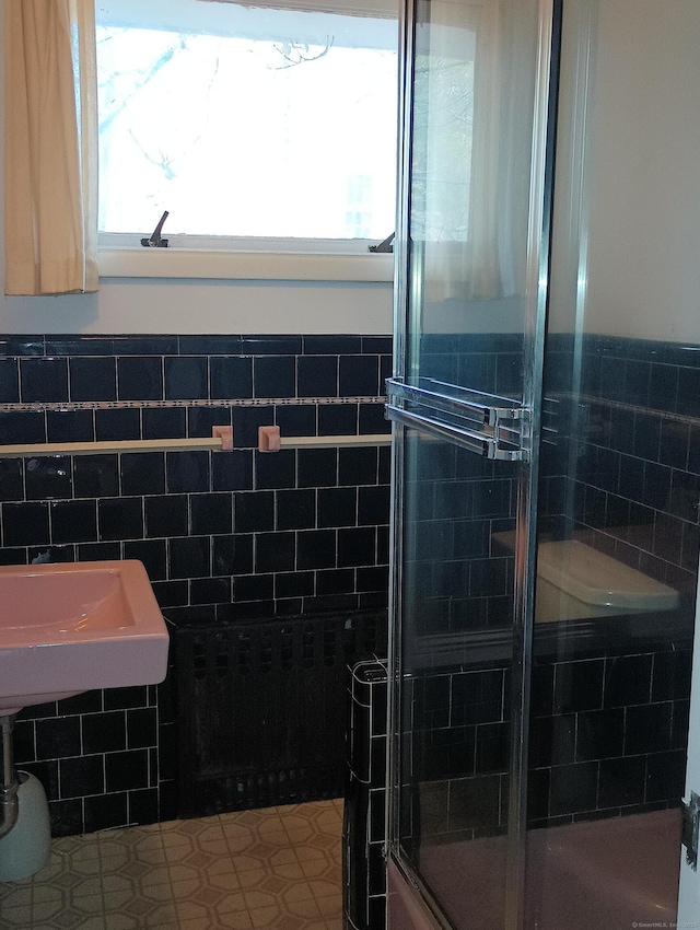 bathroom featuring walk in shower and tile walls