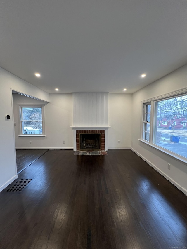 unfurnished living room featuring a fireplace and dark hardwood / wood-style floors