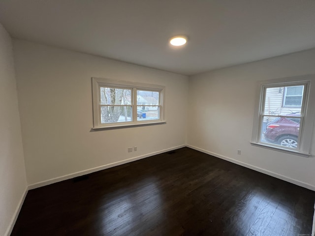 spare room with dark wood-type flooring