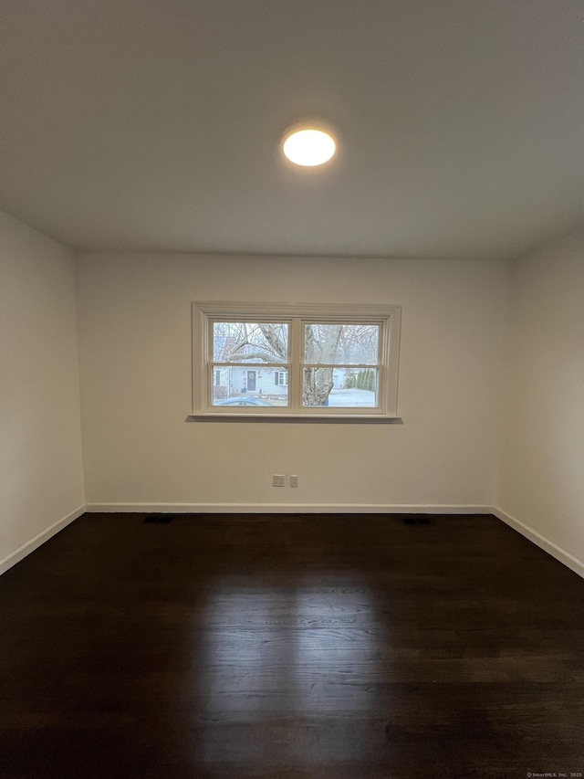 unfurnished room with dark wood-type flooring