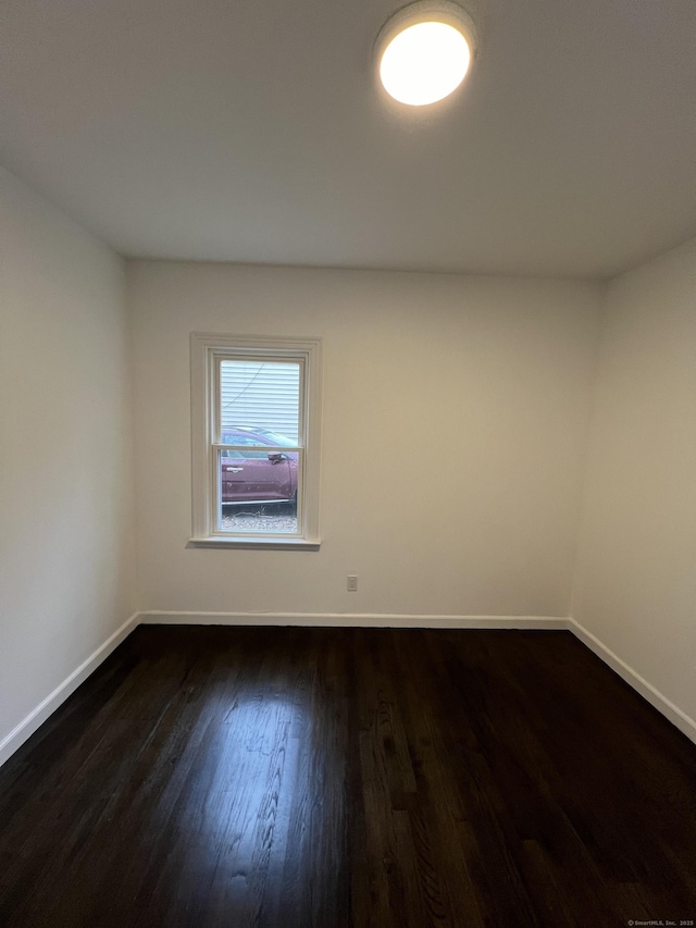 unfurnished room featuring dark wood-type flooring