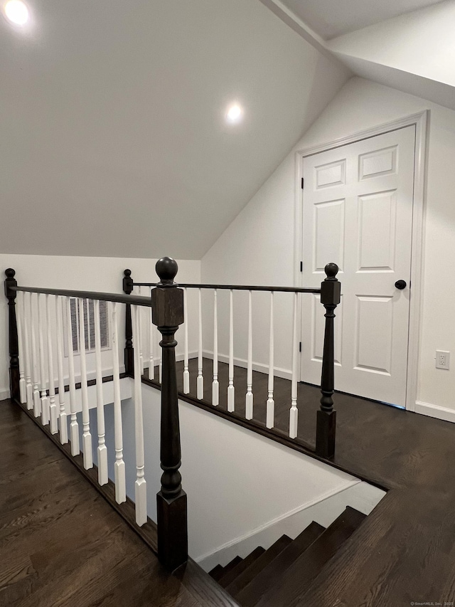 stairway featuring hardwood / wood-style flooring and vaulted ceiling