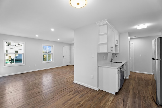 kitchen featuring appliances with stainless steel finishes, dark hardwood / wood-style flooring, white cabinetry, and sink