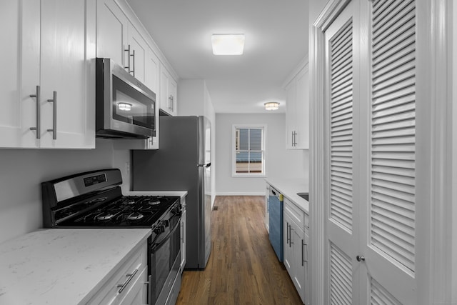 kitchen featuring white cabinets, dark hardwood / wood-style floors, light stone counters, and stainless steel appliances