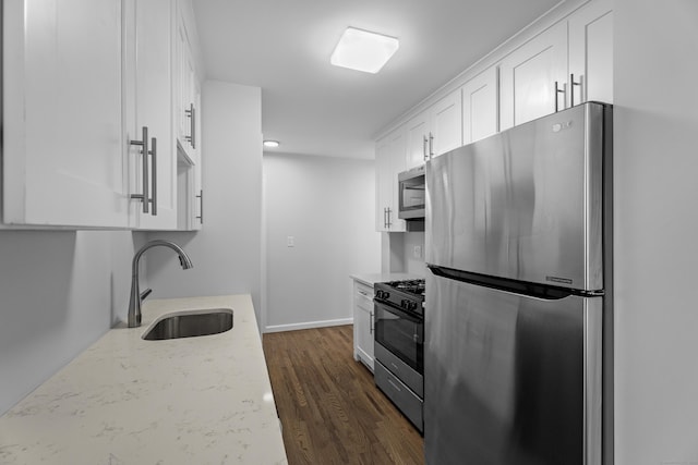 kitchen featuring sink, dark wood-type flooring, stainless steel appliances, light stone counters, and white cabinets