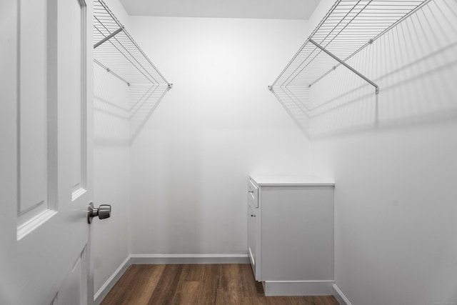 walk in closet with dark hardwood / wood-style flooring