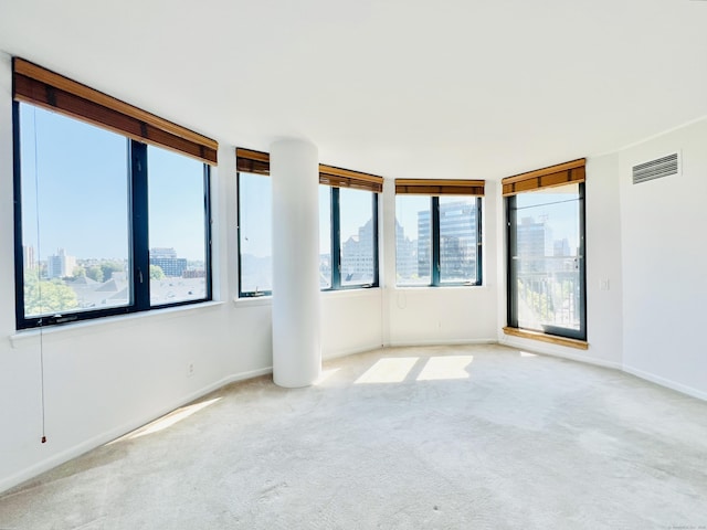 spare room with light colored carpet and plenty of natural light