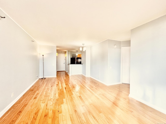 unfurnished living room with a chandelier and hardwood / wood-style flooring