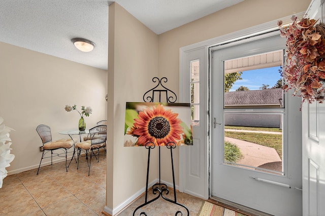 entryway featuring light tile patterned flooring and a textured ceiling