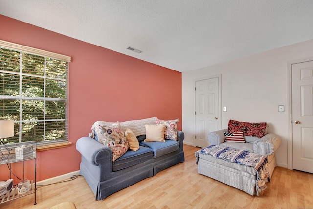 living room with hardwood / wood-style flooring, a textured ceiling, and a wealth of natural light