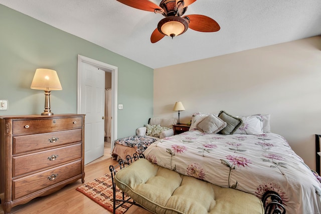 bedroom featuring a textured ceiling, light hardwood / wood-style flooring, and ceiling fan