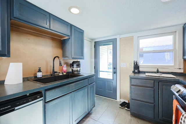 kitchen featuring stove, sink, stainless steel dishwasher, light tile patterned floors, and blue cabinetry