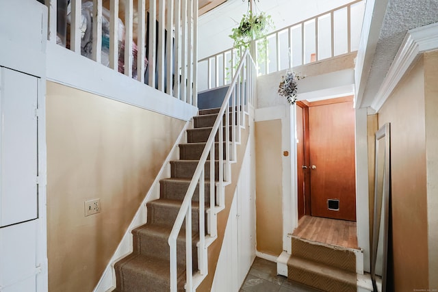 staircase with tile patterned flooring and a towering ceiling