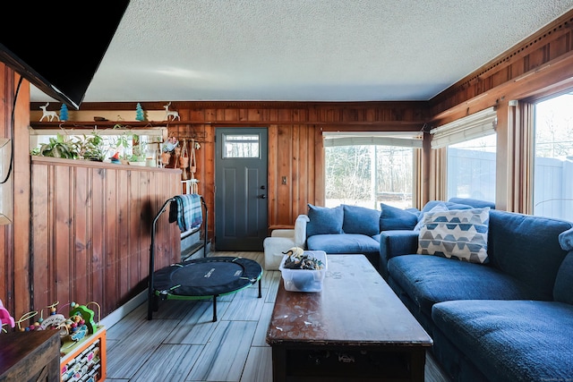 living room with wood walls and a textured ceiling