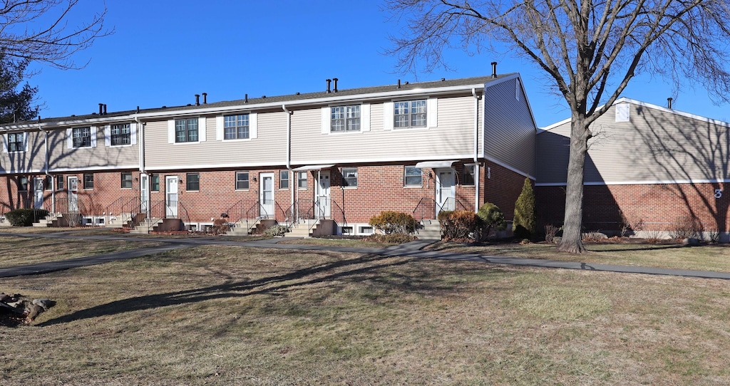 rear view of property featuring a yard