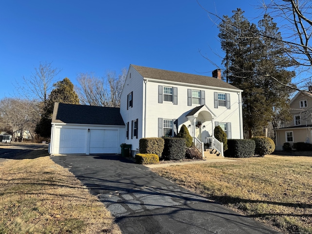 colonial house with a garage and a front lawn