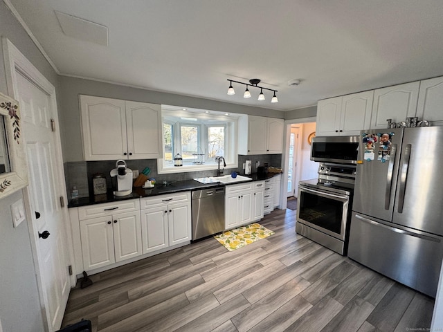 kitchen with white cabinets, stainless steel appliances, backsplash, and sink