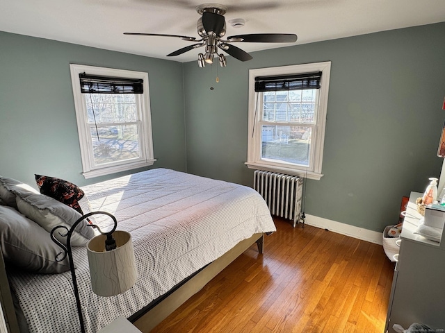 bedroom featuring hardwood / wood-style flooring, ceiling fan, and radiator