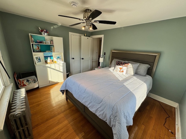 bedroom with ceiling fan, hardwood / wood-style floors, and radiator