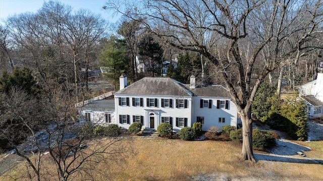 colonial-style house featuring a front yard