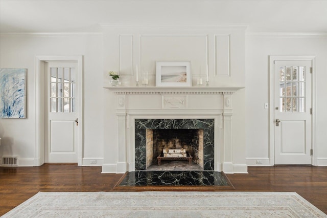 interior details with hardwood / wood-style flooring, ornamental molding, and a fireplace