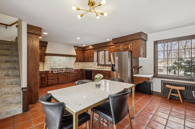 kitchen featuring a center island, radiator, appliances with stainless steel finishes, tasteful backsplash, and custom range hood